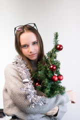 girl with a small Christmas tree hugs