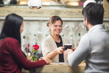 Young and beautiful barista serving coffee to customers