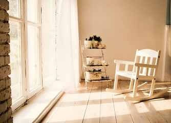 small children's chair in the white room opposite the window © ribalka yuli