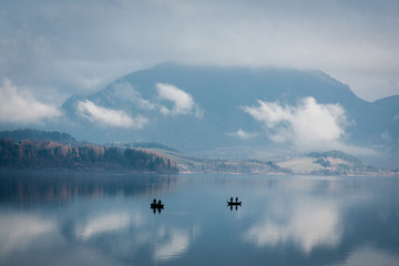 Obraz na płótnie Canvas Beautiful landscape with two fishermen boats on a lake
