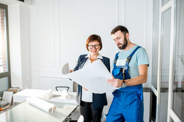 Repairman discussing the project with senior woman architect or client at the office
