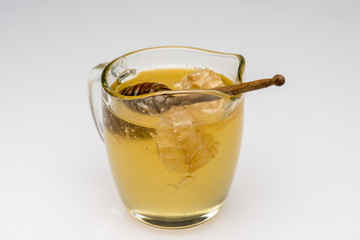 Transparent cup of honey with spoon on bright backgound