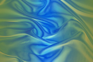 Obraz premium Light blue and green fabric with soft folds.