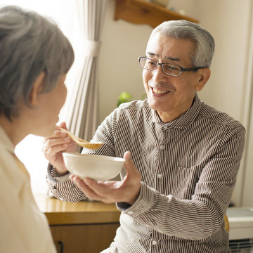 妻におかゆを食べさせる夫
