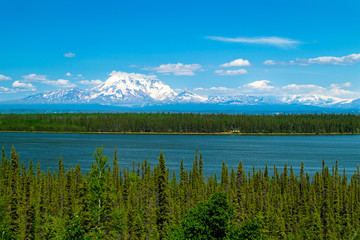 Mount Drum in Alaska. Mountains covered with snow and blue lake in front.
