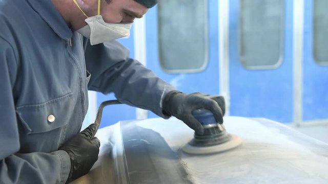 auto repairman grinding autobody bonnet