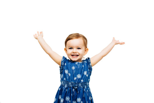 Studio portrait of smiling girl with arms raised