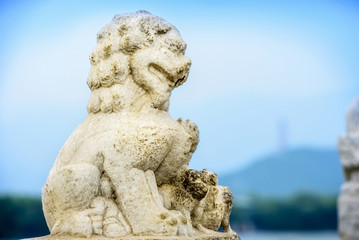 Fototapeta na wymiar Ancient Chinese guardian lion on the 17-Arch Bridge. The bridge built in Qing Dynasty, Qianlong period. Located in Summer Palace, Beijing, China.
