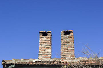 Masonry brick chimney with blue background of sky