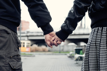 Naklejka premium Closeup of couple holding hands in the city