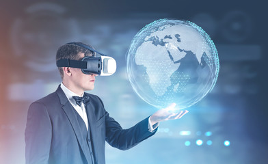 Businessman in VR glasses showing Earth hologram