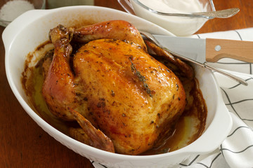 Baked chicken with herbs and garlic, served with sour cream sauce and dill. Rustic style.