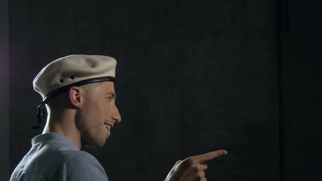 Young Man Wearing a Beret Makes Facial Expressions and Hand Gestures