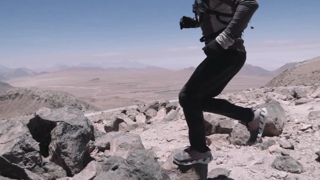 Man running down the summit of the Toco volcano on Atacama desert. Aerial view of a man running down of a volcano peak. Slow motion