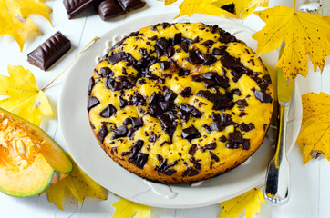 Pumpkin cake with chocolate, on a wooden table