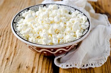Cottage cheese in a bowl on a wooden table