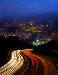 Fototapeta na wymiar Car lights at night on the road towards the city