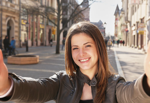young girl make a selfy on the street in spring