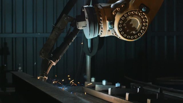 Pan of welding robot arm melt metal process at workshop. High Precision Modern Tools in Heavy Industry. Automatic work. Technology and Industrial Concept. Shot in 5K RAW
