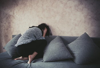 Woman in fetal position against harassment at home