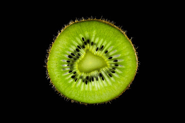 Cut a slice of kiwi on a dark background.