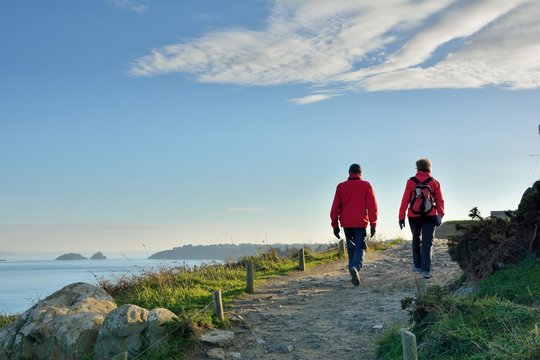Un couple de randonneurs qui marche sur le sentier c&ocirc;tier &agrave; la pointe du Grouin &agrave; Cancale en Bretagne