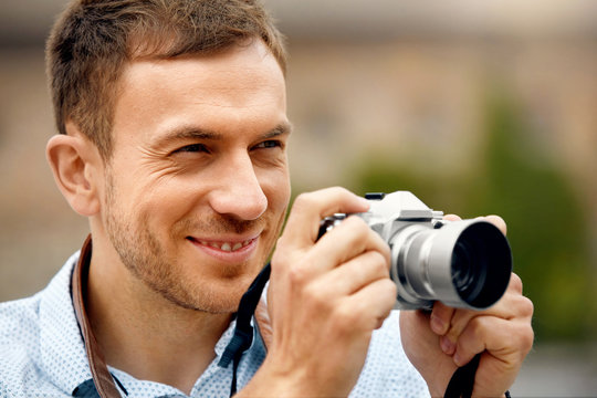 Male Photographer Taking Photos On Camera On Street