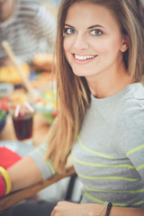 Top view of group of people having dinner together while sitting at wooden table. Food on the table. People eat fast food. Portrait of a girl