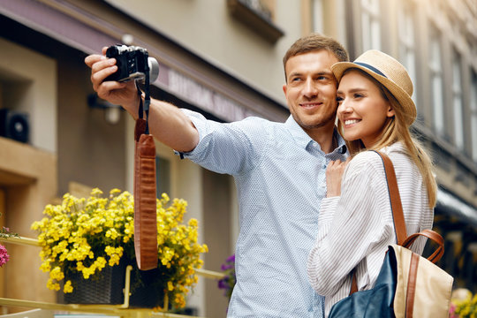 Tourist Couple In Love Taking Photos During Travel.