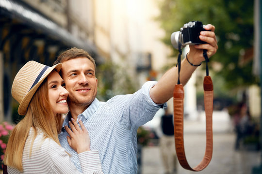 Beautiful Couple Taking Photos With Camera On Street.