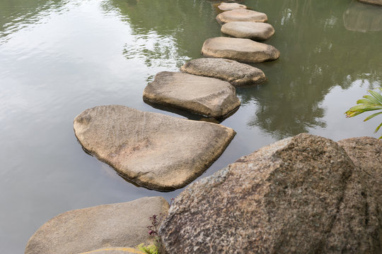 Bridge of stones on the surface of the lake in the YaNoDa tropical park in China on the Hainan Island