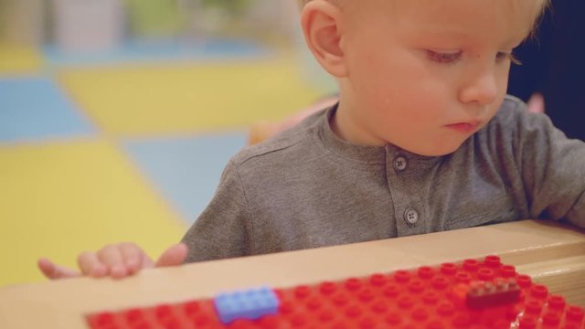 Mom and toddler son play with construction kit