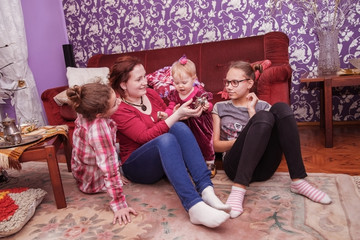 Family: mother with three children playing in the living room.