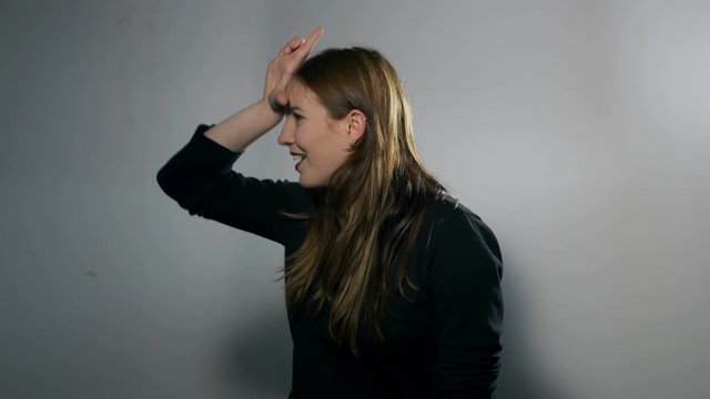 Portrait of a Female Model: Loser Hand Gesture From Profile