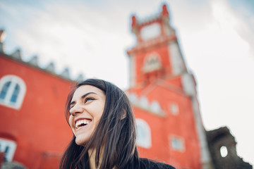 Female tourist admiring popular Portuguese historical landmark National Palace of Pena,royal caste of Portugal.Colorful Romanticist architectural wonder.Woman visiting UNESCO World Heritage in Sintra