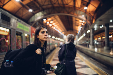 Female traveler searching for directions,waiting for the train/tram,using transportation in foreign country.Urban tourism.Low budget cheap ticket backpacking.Travel to the destination