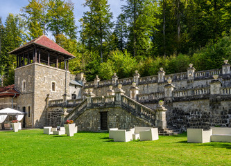 Cantacuzino Palace garden with exterior furniture and a guard tower on a sunny bright warm day
