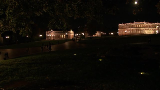 People walk near towers and fortresses of red brick in Tsaritsyno at night. Family holiday at weekend in parks and museums of capital Russia Moscow,
