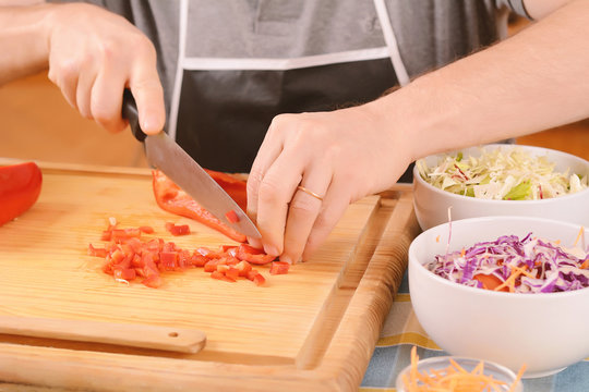 Close up of man cutting vegetables on the board