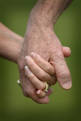 Closeup of a Married Senior Citizens Holding Hands. A loving closeup scene of a senior married couple holding hands with wedding rings.