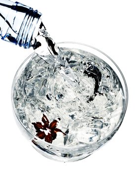 Close Up Of Bottle Pouring Liquid Into Glass