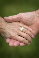 Closeup of a Married Senior Citizens Holding Hands. A loving closeup scene of a senior married couple holding hands with wedding rings.