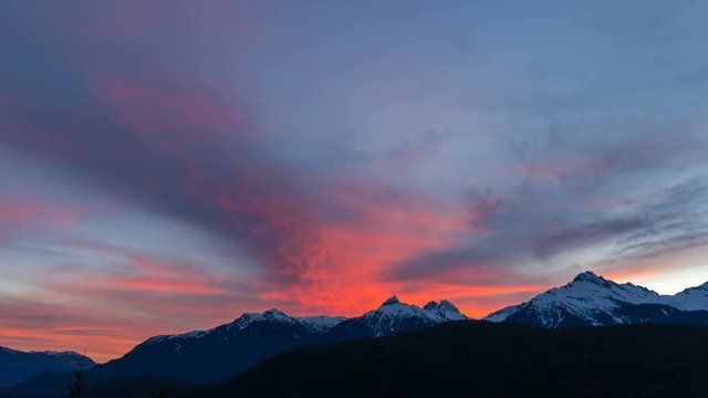 Ultra high definition time lapse movie of moving clouds and blue sky over snow covered Tantalus Range in British Columbia Canada during winter season at colorful sunset 3840x2160 UHD