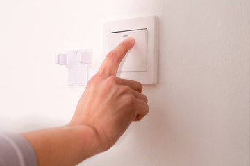 turning off/on the wall-mounted electric light switch.