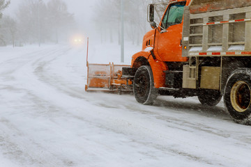 Tractor removing snow from residential housing estate in winter