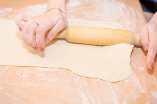 The girl rolls out the dough