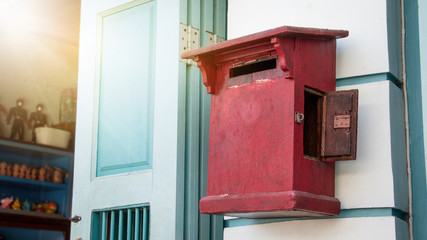 Close up of red old vintage wooden mailbox in front of vintage store. Red Asia wooden mail box on wooden vintage wall.