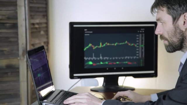 trader working on laptop on crypto stock exchange. businessman keep track of exchange currency exchange chart at the computer monitor