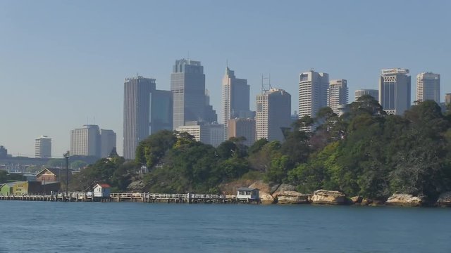 A wide shot of trees and coties. Camera pans to the left. 