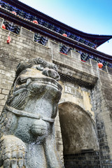 Ancient Chinese guardian lion and North Gate of Dali Old Town. Located in Yunnan, China.